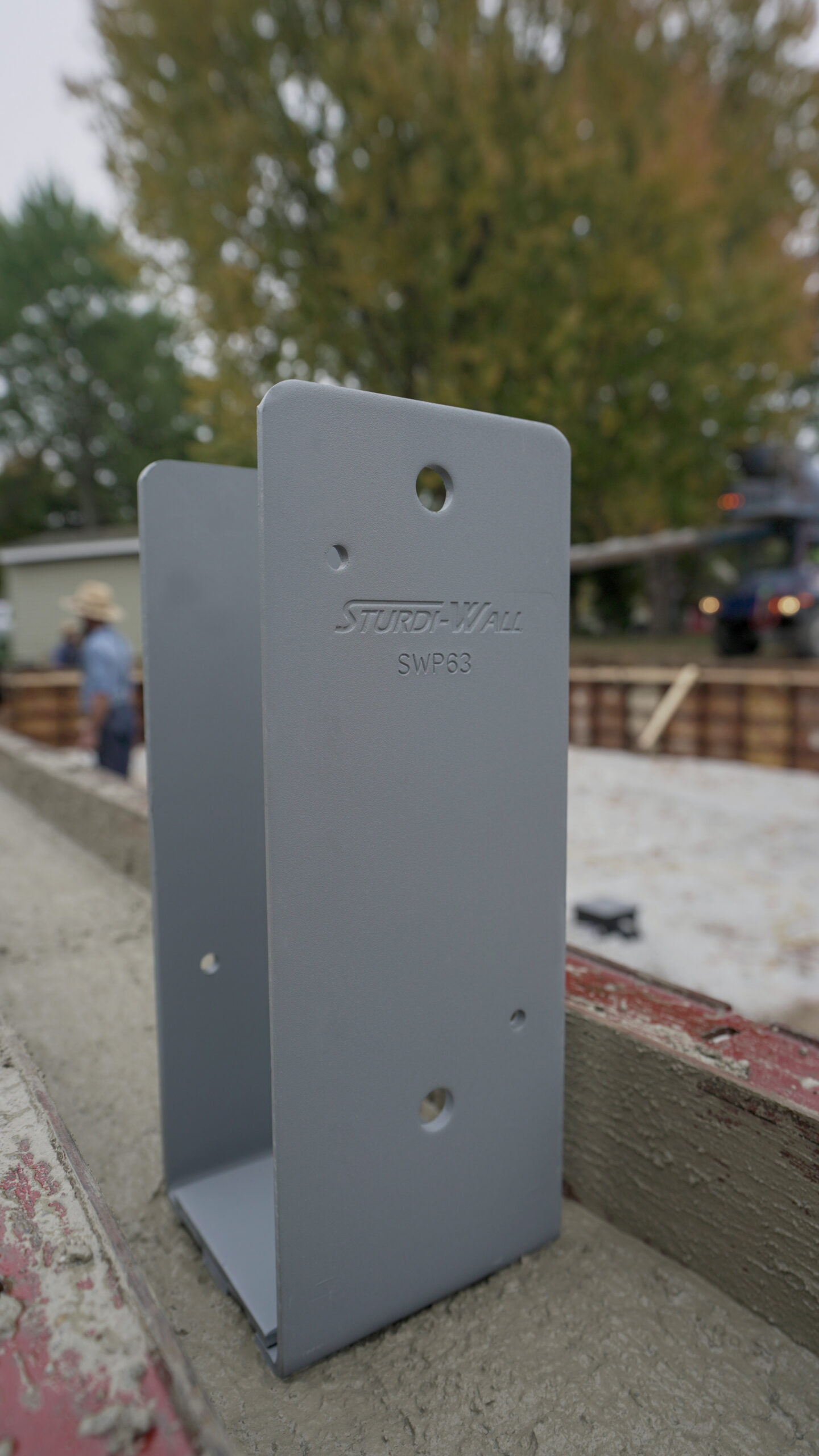 A sturdi-wall bracket sits on top of a poured concrete foundation