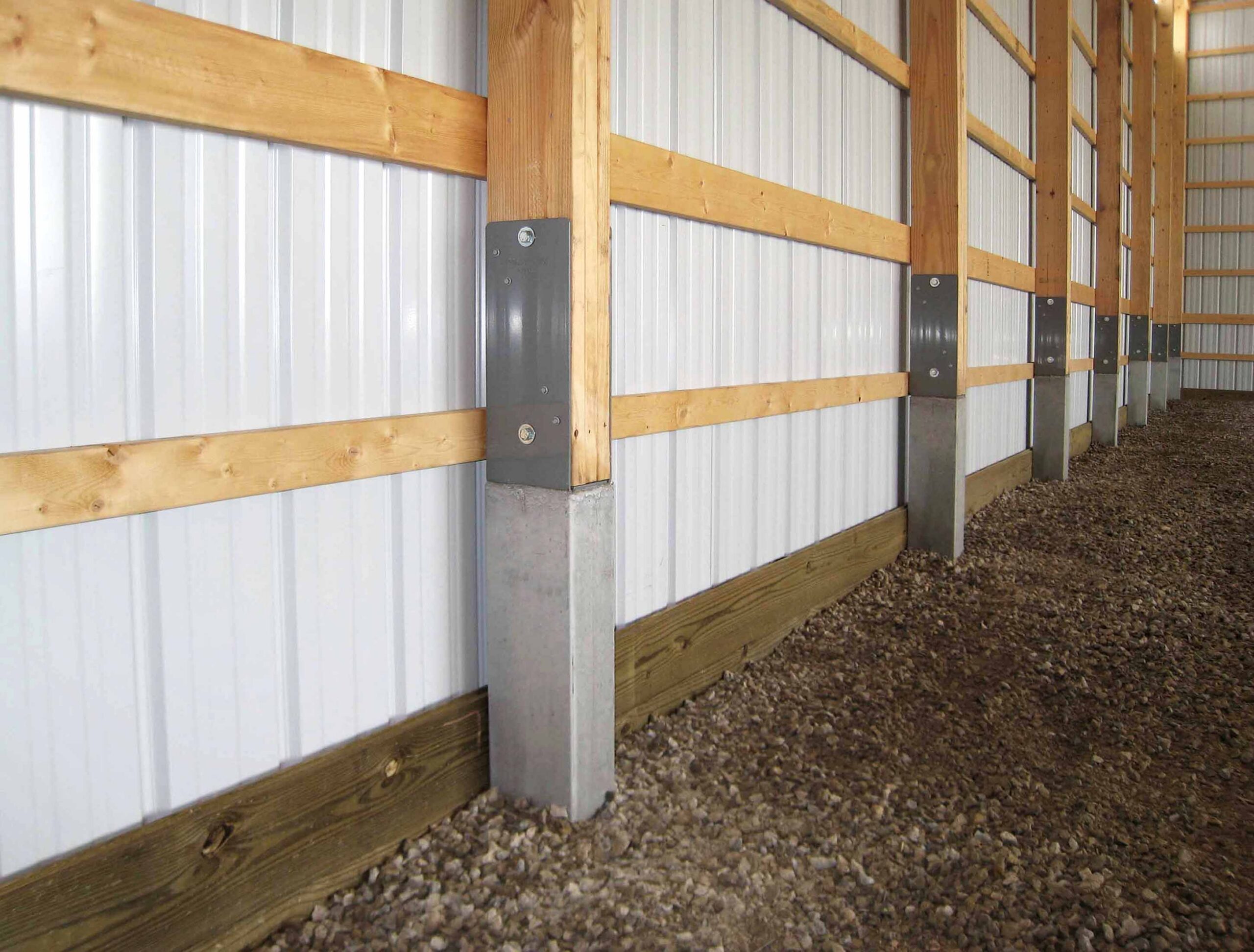 Prema-columns are preceast concrete columns for horse barns shown inside a horse barn installed
