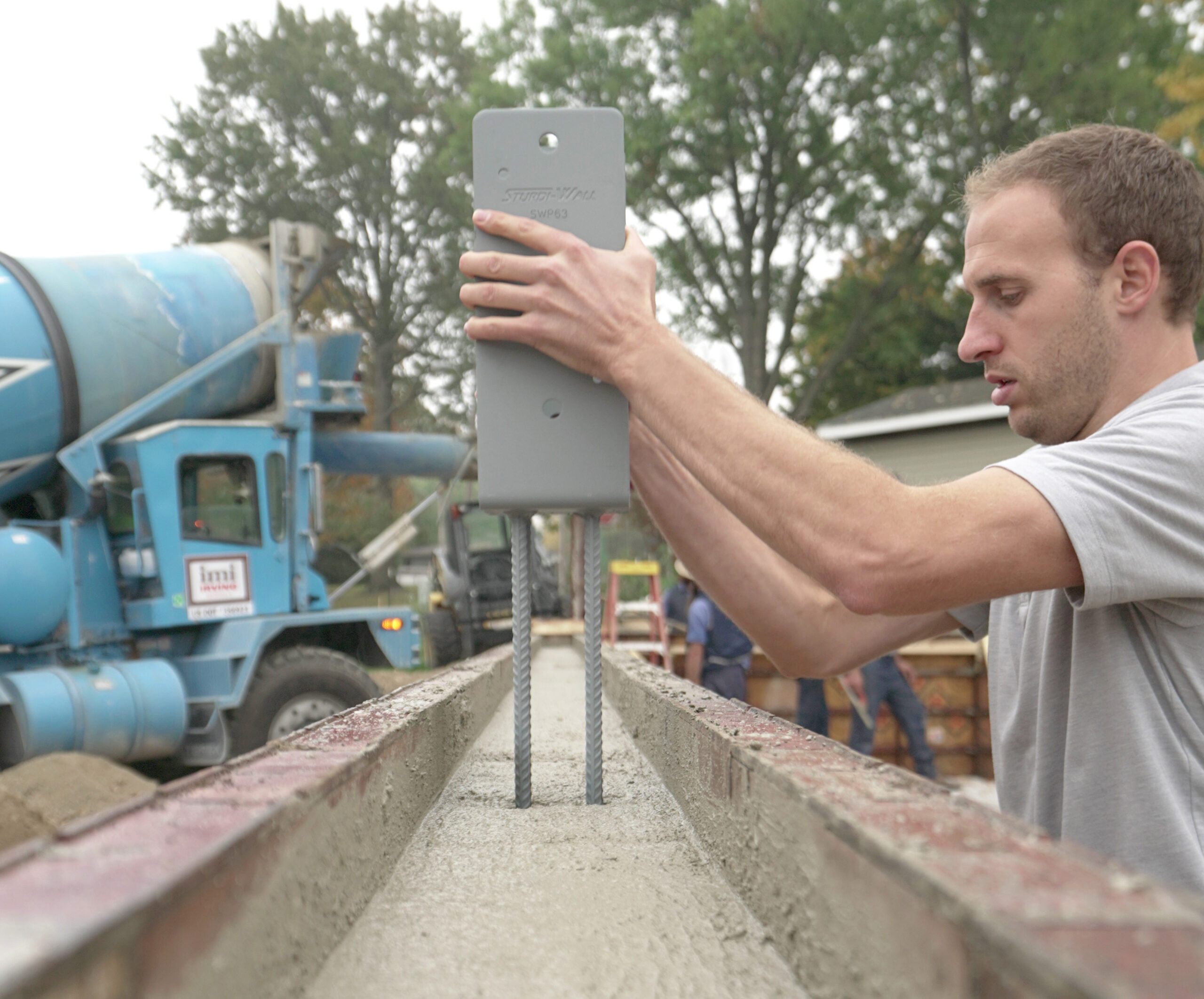 A worker set a sturdi-wall bracket on its concrete base